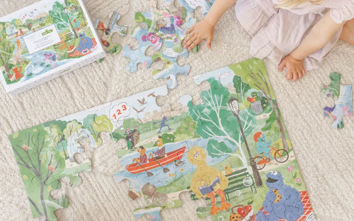 Child playing with a Sesame Street floor puzzle